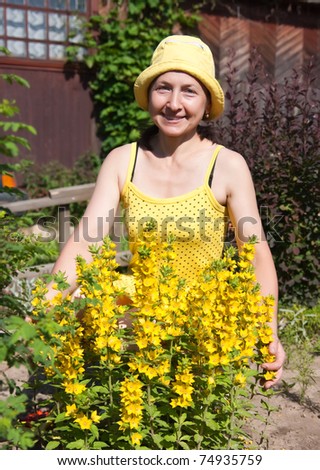 Mature, middle-aged woman plants flowers in garden