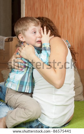 crying child and his careful mom in home interior