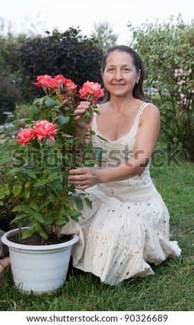 Female gardener in rose plant at garden