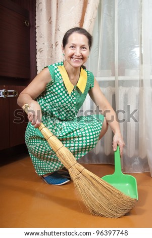 woman with a broom is cleaned in an apartment