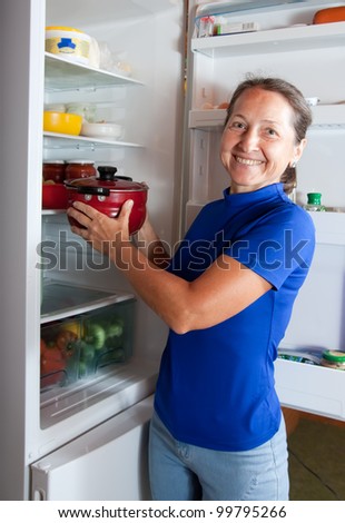 Ordinary    woman taking something of the fridge