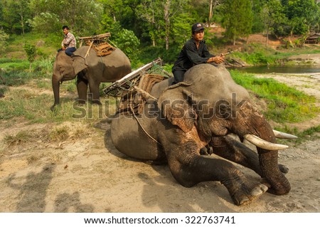 KANCHANABURI/THAILAND - MAY 2015 - Elephant mahouts ordered to sit down . In order to allow tourists onto its back. MAY, 9, 2015 in Kanchanaburi, Thailand.