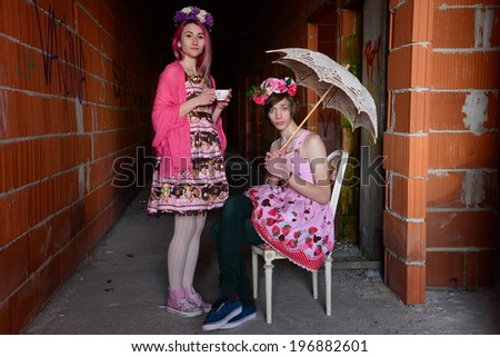 A beautiful lady and a young man dressed in special dress having a tea time.