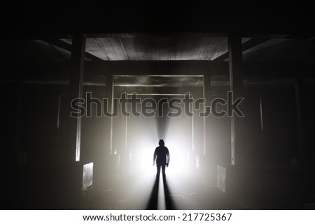 A human silhouette in an abandoned hallway.