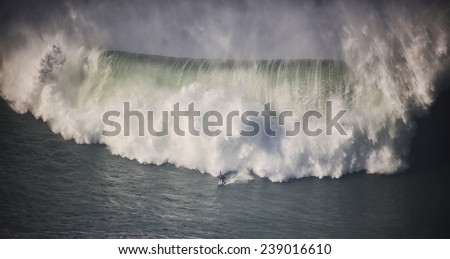 A surfer on a huge wave in Nazare, Portugal.