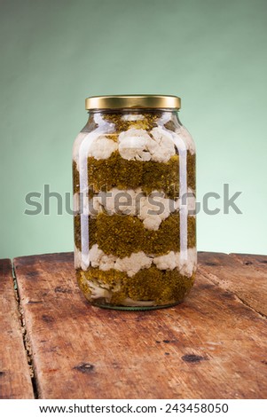 Salad jar on a wooden table with green background