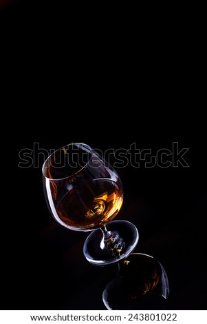 Glass with cognac alcohol isolated on a black background