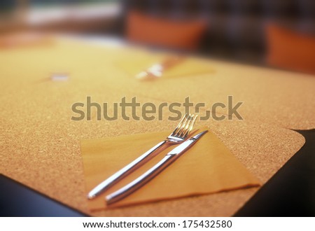 Empty dinner table with fork and knife.