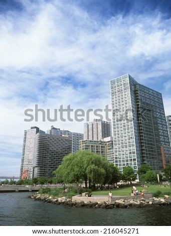 New York City, Long Island, USA - June 8, 2014: People having a rest by East river in Long Island City park in Queens, New York.