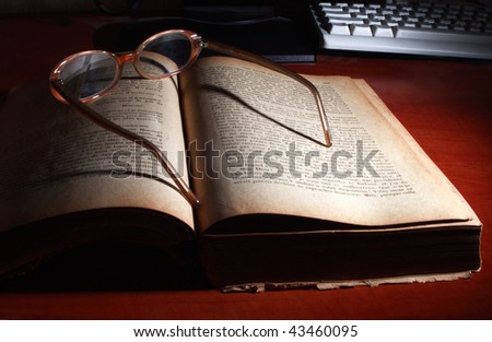 Old book, glasses and computer keyboard.