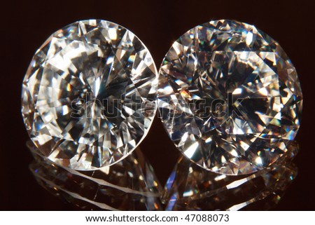 Two elegant diamonds with reflection on the floor.