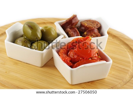Platter with tapas, tomatoes, olives and  marinated sausages isolated on white