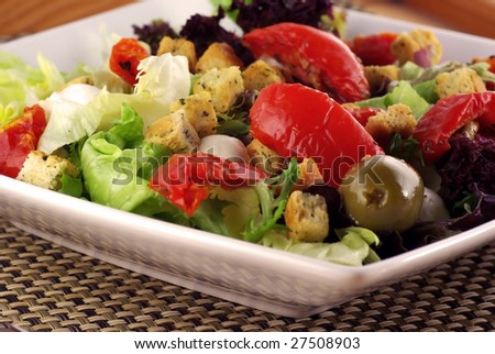 Close up of a salad platter with olives, dried tomatoes, mozarella & croutons