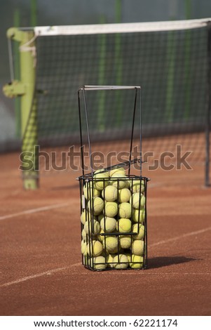 Basket with tennis balls on a court