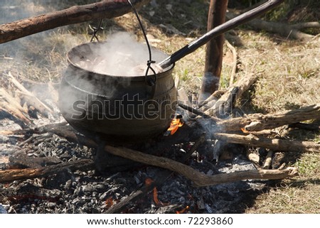 Cooking in kettle on fire in the nature