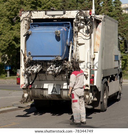 Garbage collector loading waste on the street