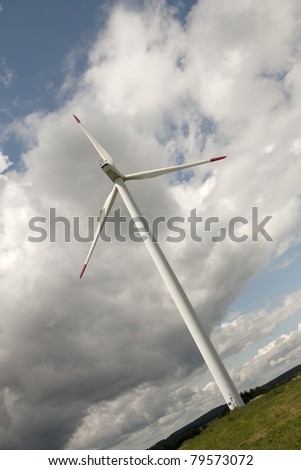 Wind power station in the country over cloudy sky