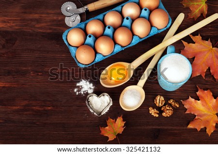 Ingredients for cooking; eggs; yolk; wooden spoons; Blue cup; sugar; Sugar in a wooden spoon; frame; background; background for recipes; space for writing text