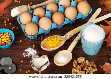 Ingredients for cooking; recipes; eggs; yolk; wooden spoons; Blue cup; sugar; Sugar in a wooden spoon; background for recipes; autumn menu; autumn background