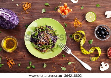 Vegetarian concept. Salad of raw vegetables on a green plate. Products for quick weight loss. A balanced menu of vegetables such as cabbage, carrots, arugula.