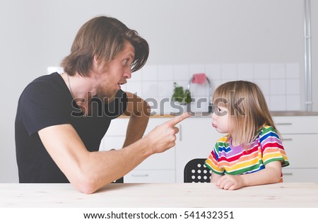 displeased father scolding his kid in preschool age at home, screaming and pointing with finger