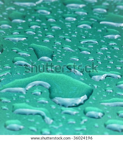 Abstract teal metal background with raindrops collected on it