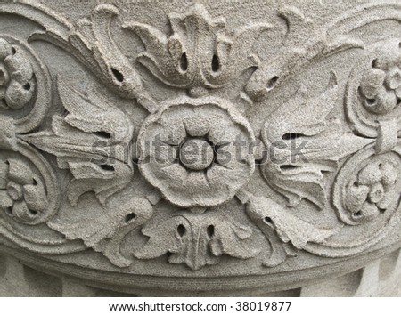 Ornate floral design carved into old stone wall