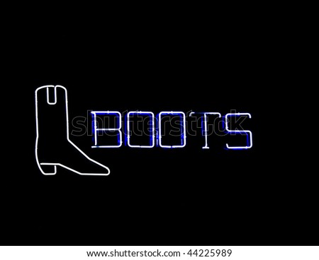 Neon sign shaped like a cowboy boot found in the window of retail shoe stores