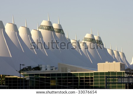 Denver International Airport at dawn with sunlight hitting peaks