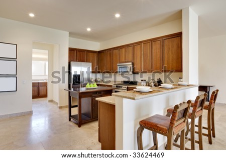 Wide view of kitchen with center island, countertops, and cabinetry