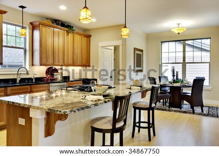 Elegant, brightly lit kitchen with island and light wood cabinetry