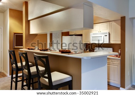 Kitchen area of apartment with high bar-style countertop