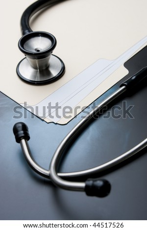 Medical Records with X Ray and Stethoscope. Focus on stethoscope bell.