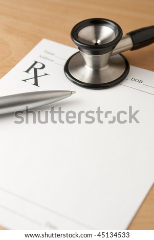 Prescription Document with Pen and Stethoscope. Critical focus on tip of pen.
