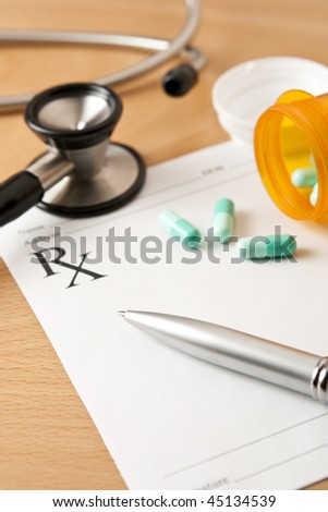 Critical focus on tip of pen. Stethoscope and bottle cap beyond depth of field.