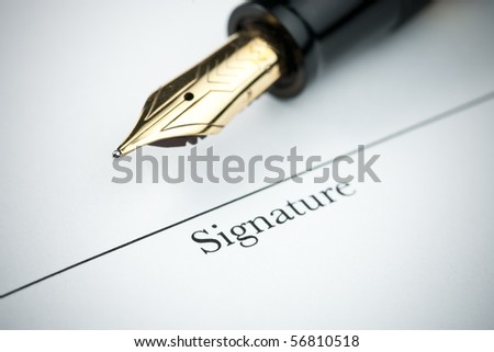 Pen resting above signature line of document. Focus on tip of pen nib.