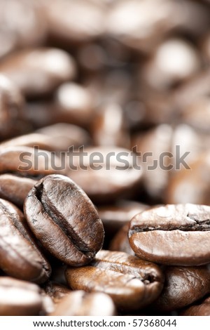 Coffee beans with selective focus on single bean on lower left side of frame.