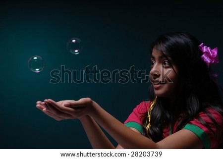 cute girl trying to grab two soap bubbles