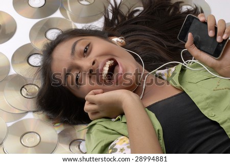 beautiful girl lying with portable CD player on the floor listening music with audio CD