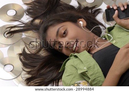 beautiful girl lying with portable CD player on the floor listening music with audio CD