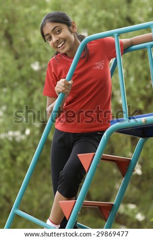 young girl climbs on steps of slide
