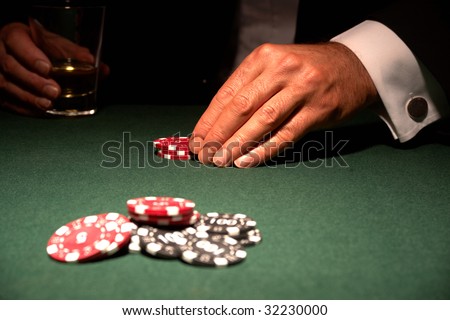 Card player in casino with chips and drink