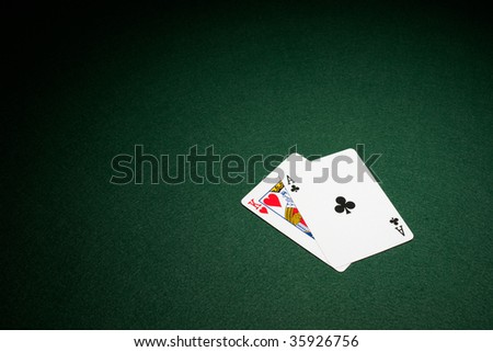 Blackjack hand on green baize table ace and king