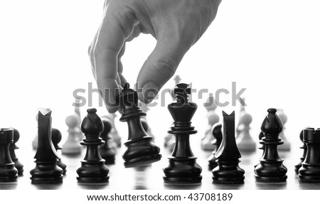 Chess move with hand picking up the queen black and white