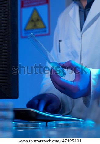 Scientist entering data  from biotechnology experiment into computer