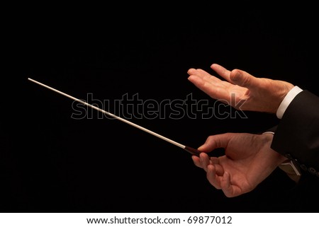 Concert conductor hands with baton isolated on black background