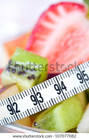 Fruit salad and strawberry with measure tape, diet concept