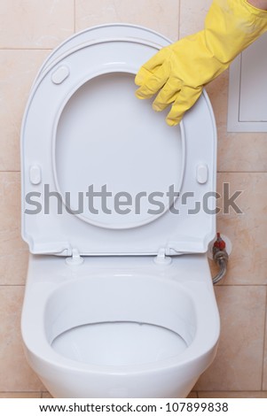 WC hygiene concept, hand in yellow glove making signs