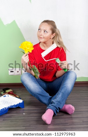 Young woman painting interior wall of home