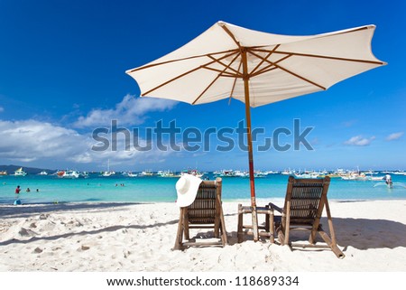 Sun umbrella with Summer Hat on chair longue